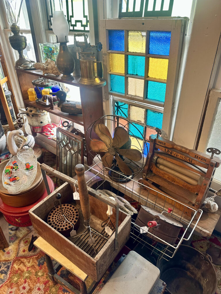 Various antiques including stained glass windows. oil lamps, kitchen utensils and housewares